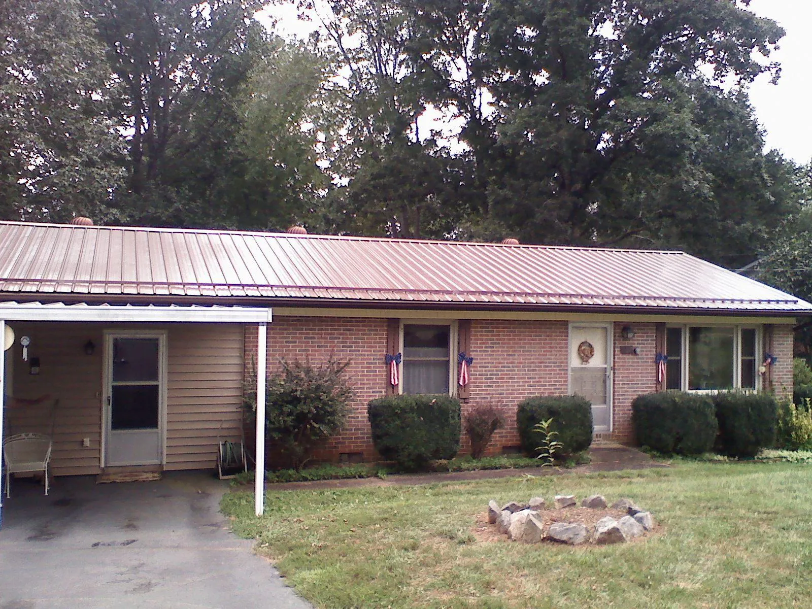 Bronze metal roof and carport on a brick ranch home — Roof Repair work by our crew in Lake Jackson