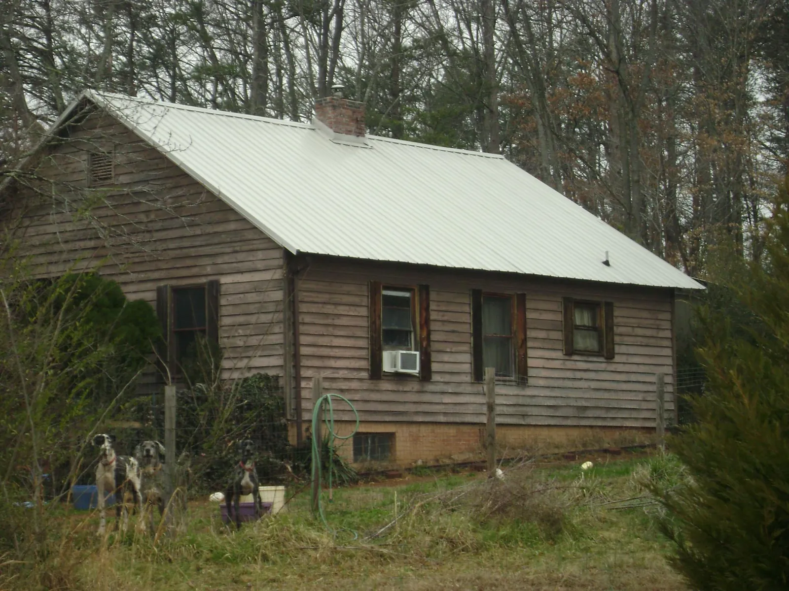 White metal roof on an old wood sided farmhouse, from a Metal Roof Installation job in Lake Jackson